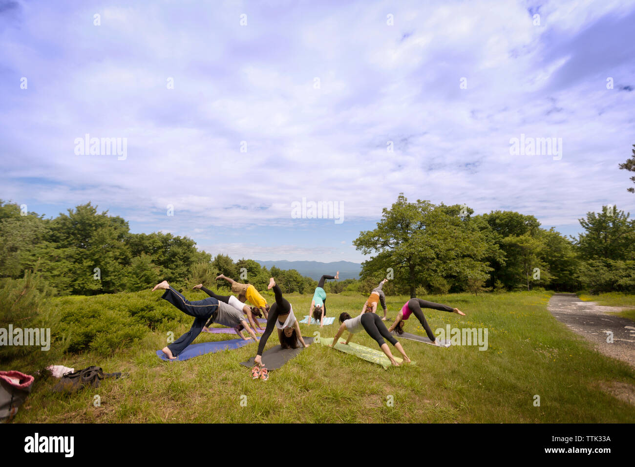 Freunde Ausübung auf Feld gegen bewölkter Himmel Stockfoto