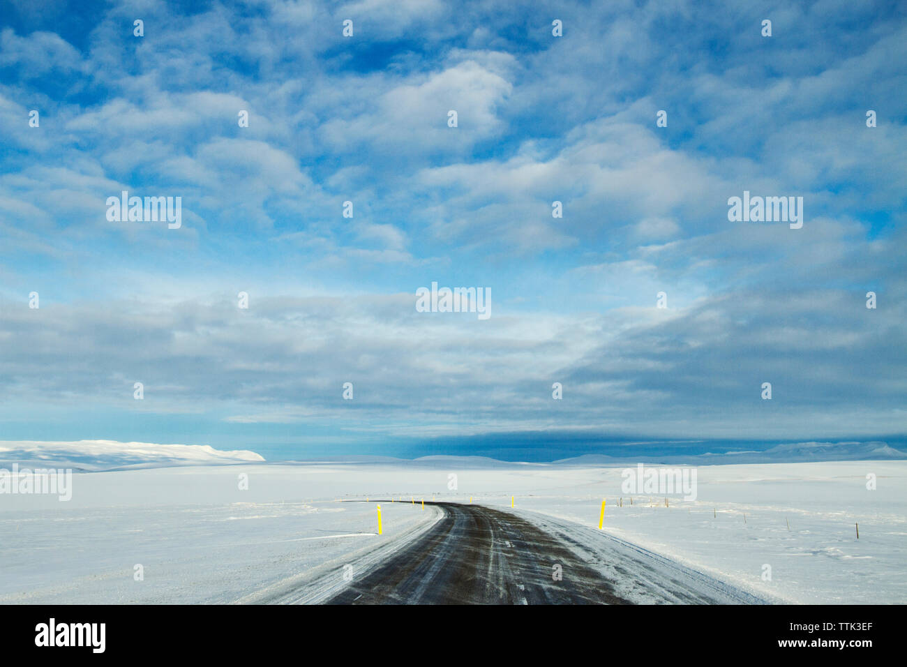 Leere Straße inmitten einer schneebedeckten Feld gegen Sky Stockfoto