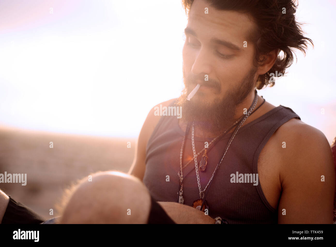 Hipster das Rauchen von Marihuana gemeinsame während der Sitzung gegen den klaren Himmel Stockfoto