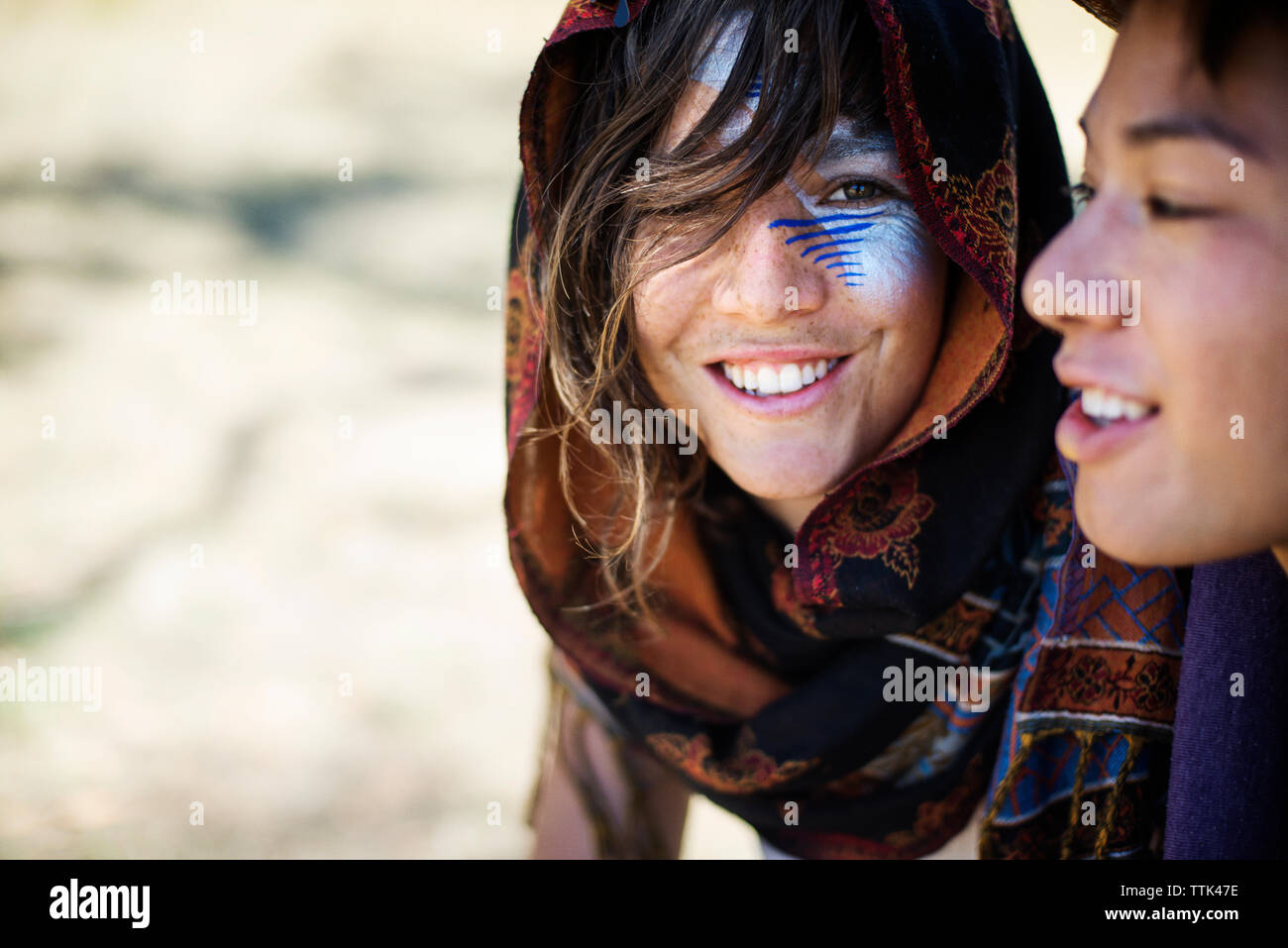 Lächelnd Freunde mit Gesicht Farbe sprechen während der traditionellen Veranstaltung Stockfoto