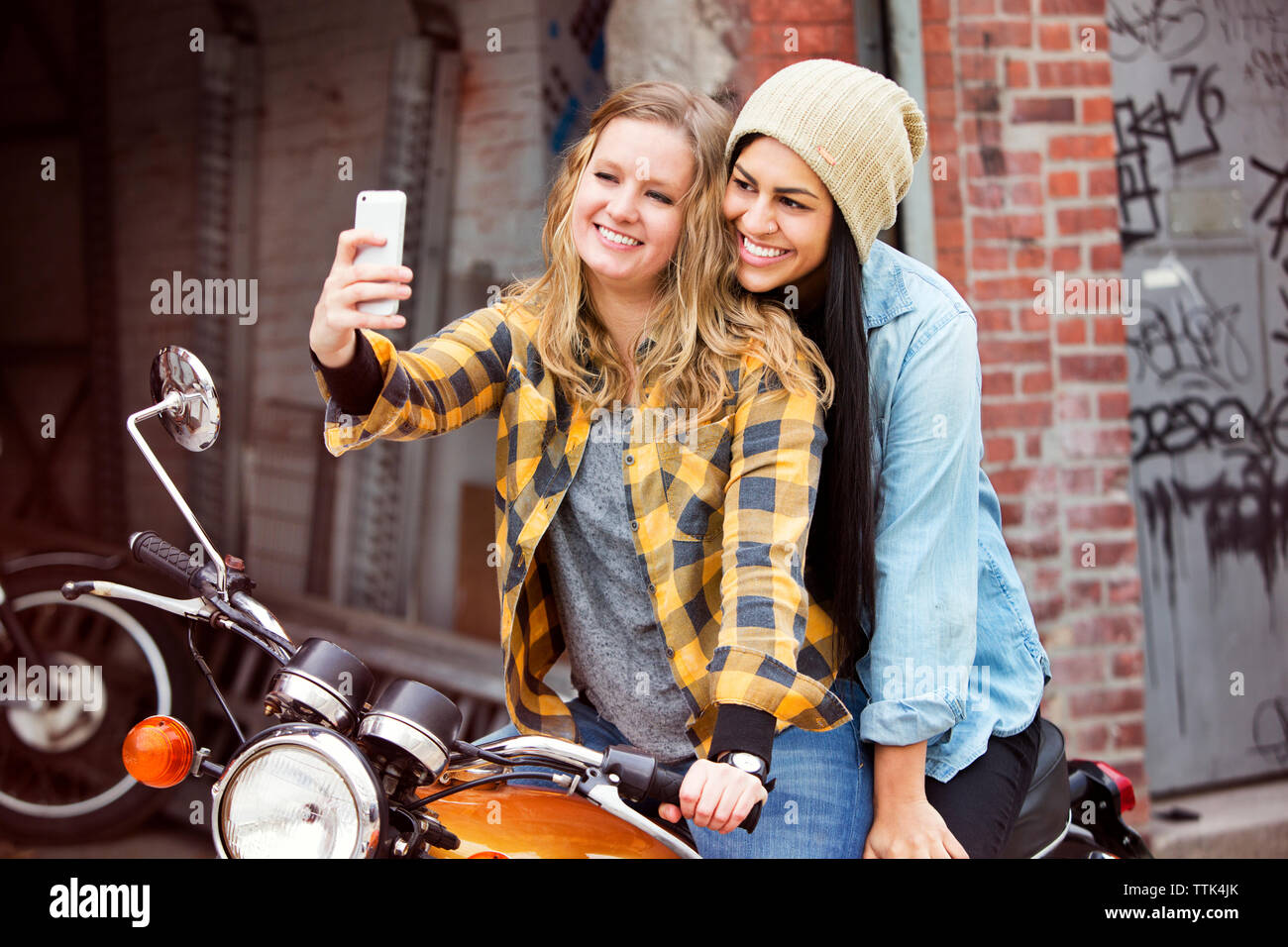 Gerne weibliche Freunde unter selfie beim Sitzen auf dem Fahrrad Stockfoto