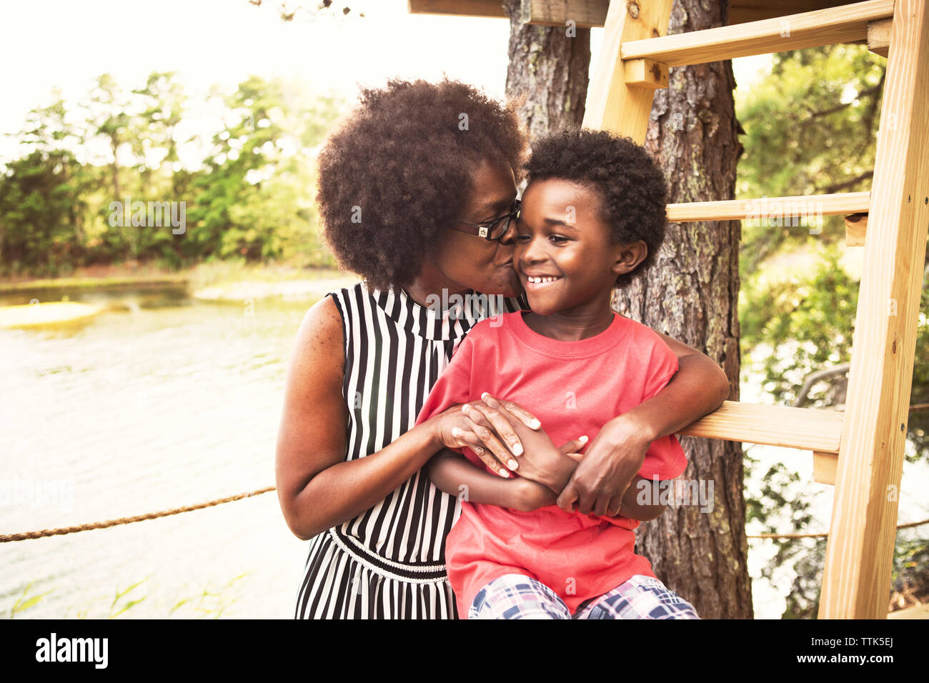 Mutter küssen Sohn auf Wange am Seeufer Stockfoto