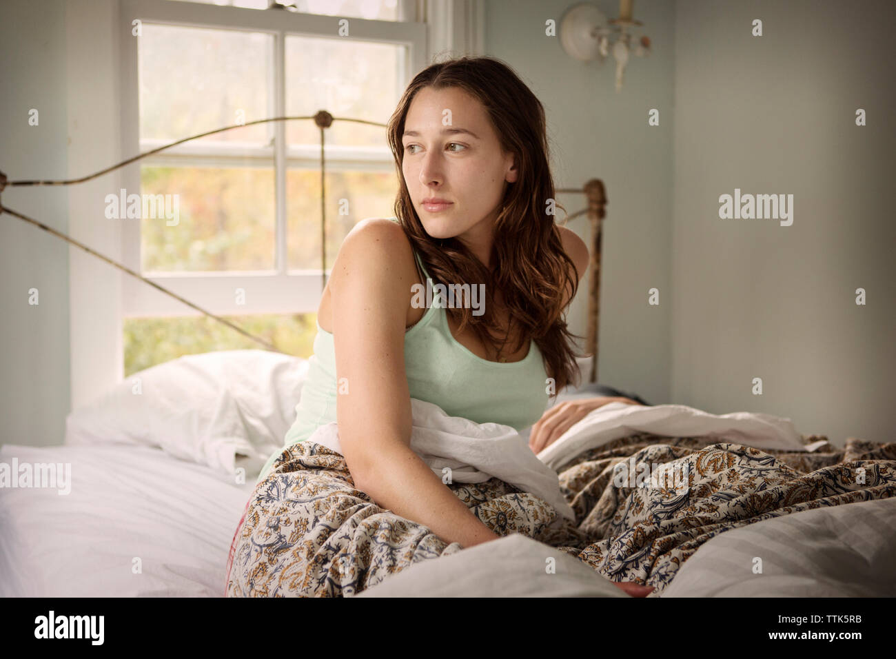 Junge Frau auf dem Bett aufwachen. Stockfoto