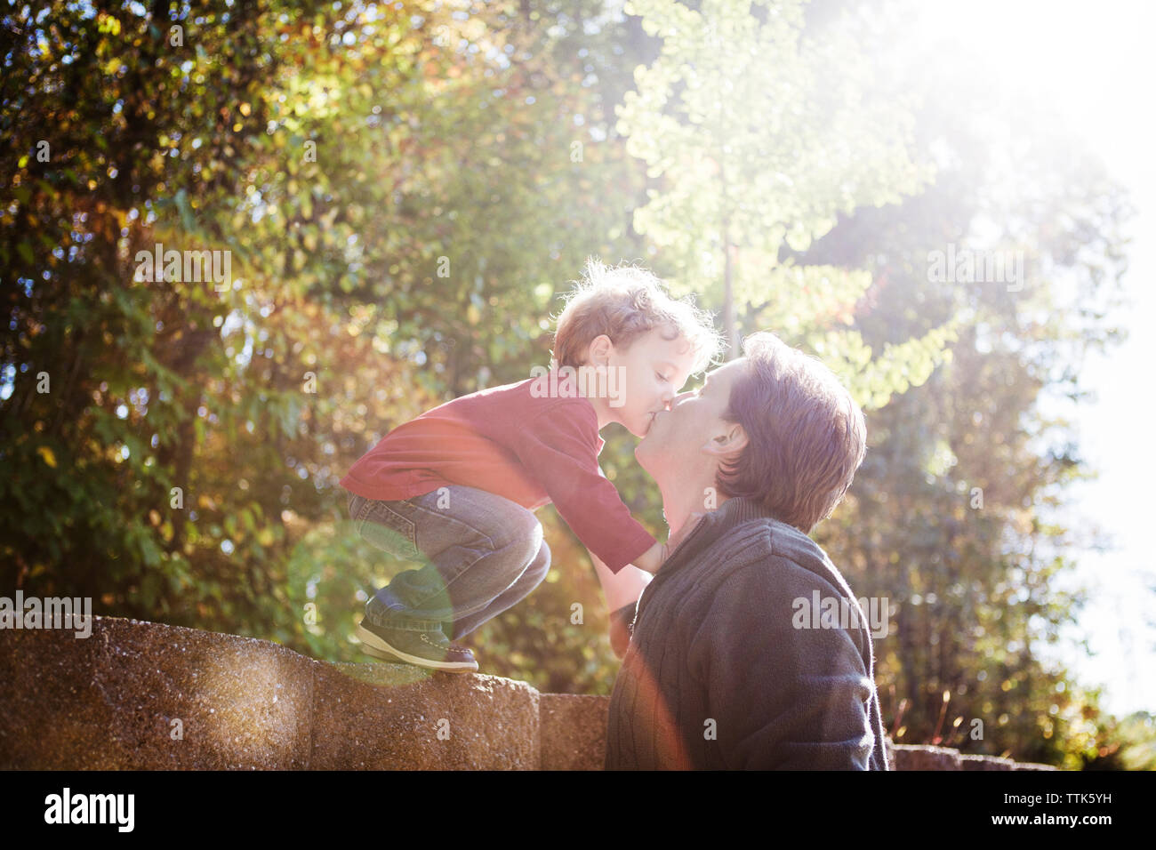 Vater und Sohn Küssen an der Stützmauer Stockfoto