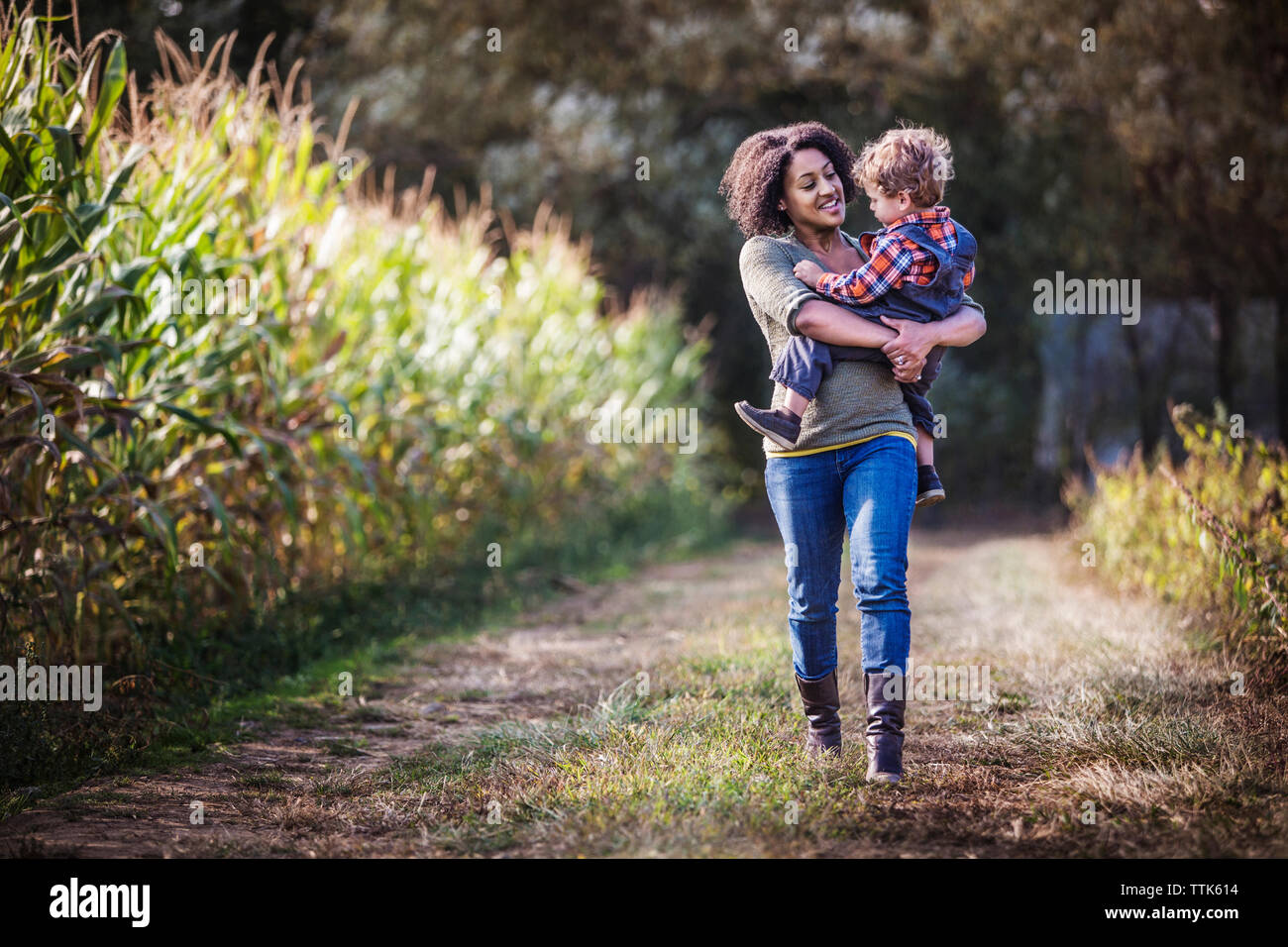 Mutter mit Sohn beim Gehen auf Feld Stockfoto