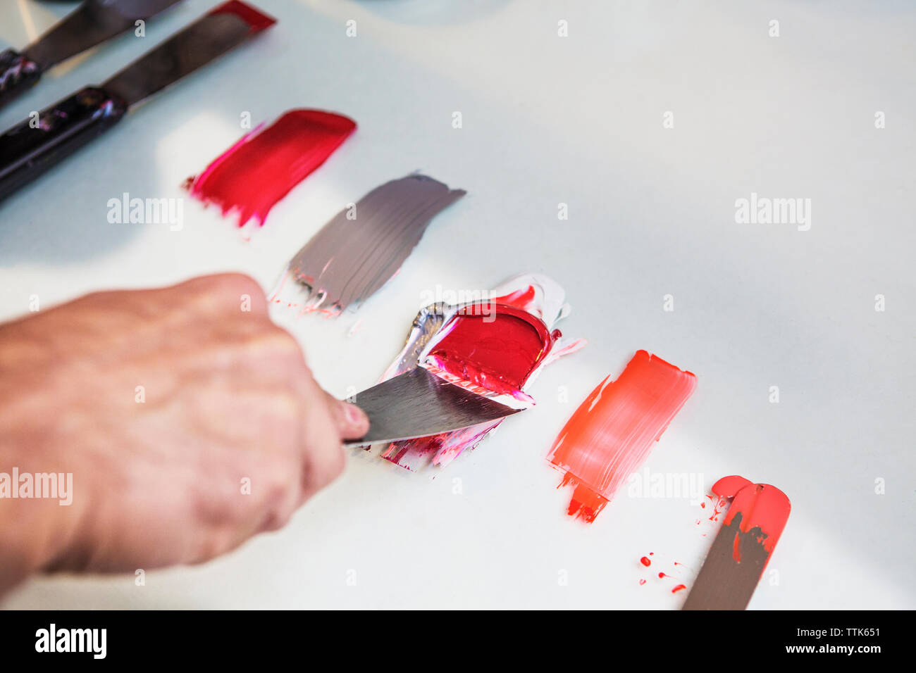 Zugeschnittenes Bild der Hand Mischen von Farben auf Tisch in Werkstatt Stockfoto