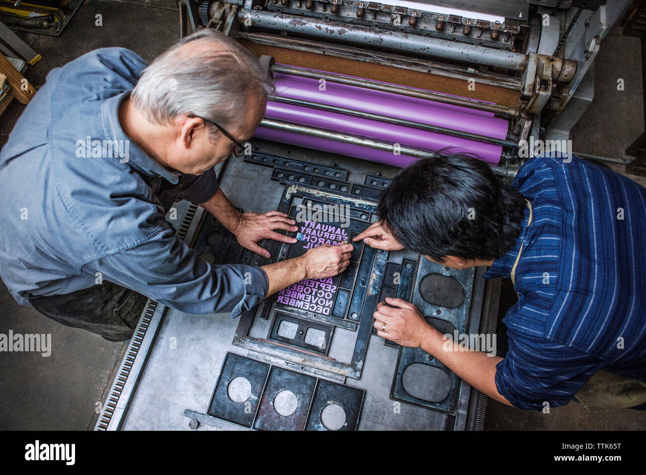 Hohe Betrachtungswinkel der Arbeitnehmer zur Festsetzung Buchdruck auf Maschinen in der Werkstatt Stockfoto