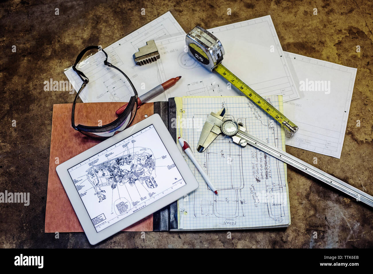 Ansicht von oben Blaupause und Ausrüstung auf Tisch in Werkstatt Stockfoto