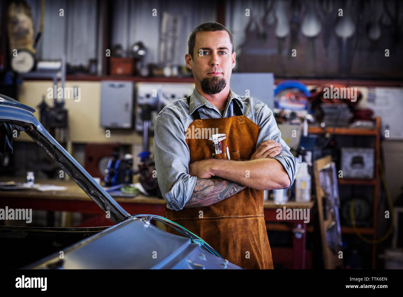 Portrait von Mechaniker stehen mit der Waffe in der Werkstatt gekreuzt Stockfoto