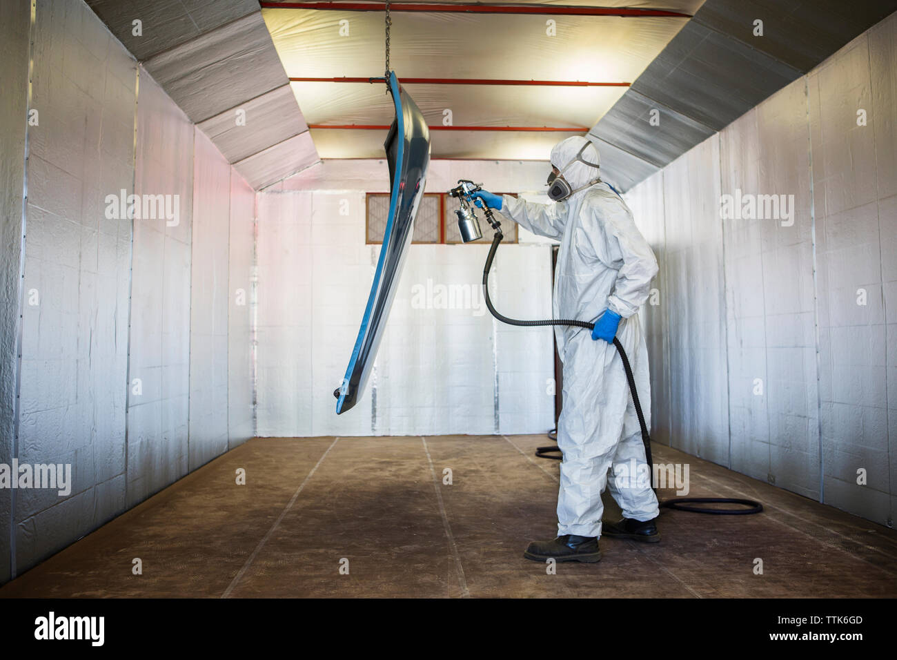 Seitenansicht der Mechaniker Malerei Fahrzeug Teil in Auto Body Shop Stockfoto