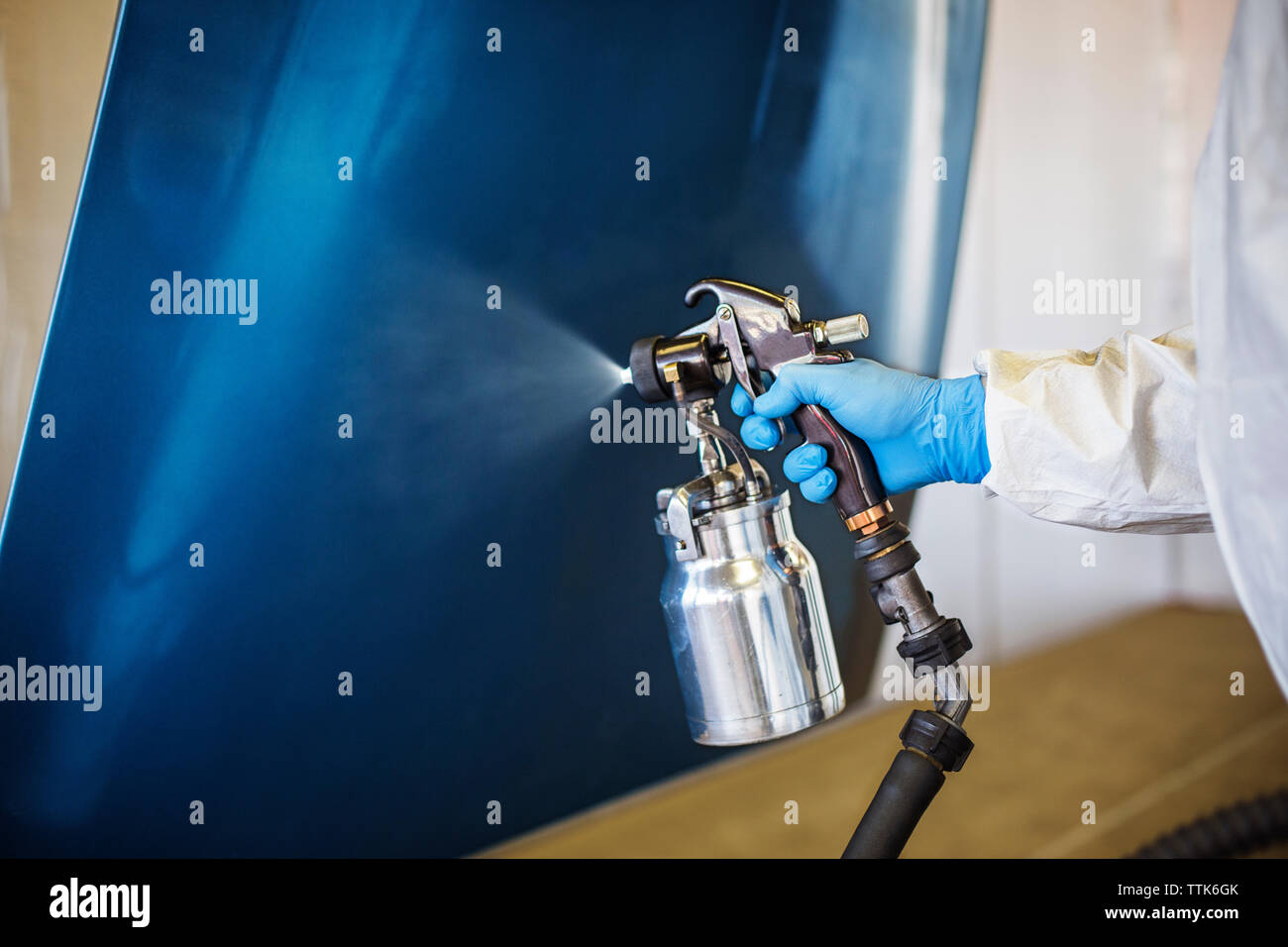 Nahaufnahme der Mechaniker hand Malerei Fahrzeug Teil in Auto Body Shop Stockfoto