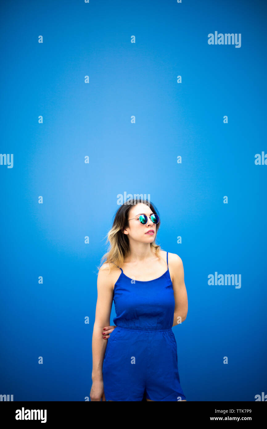 Junge Frau sich gegen blaue Wand Stockfoto