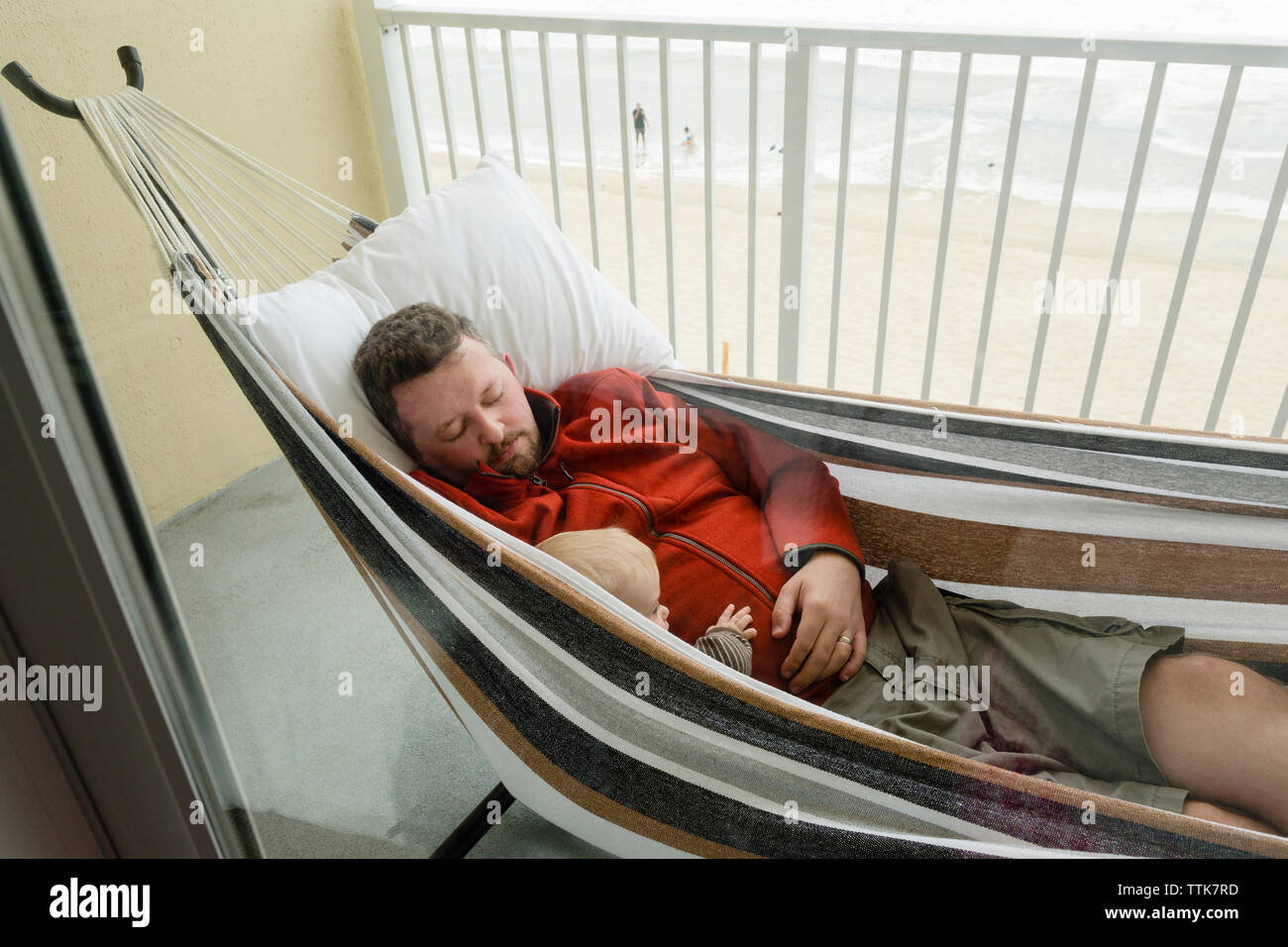 Vater und Sohn ruht in der Hängematte auf dem Balkon, durch das Fenster  gesehen Stockfotografie - Alamy