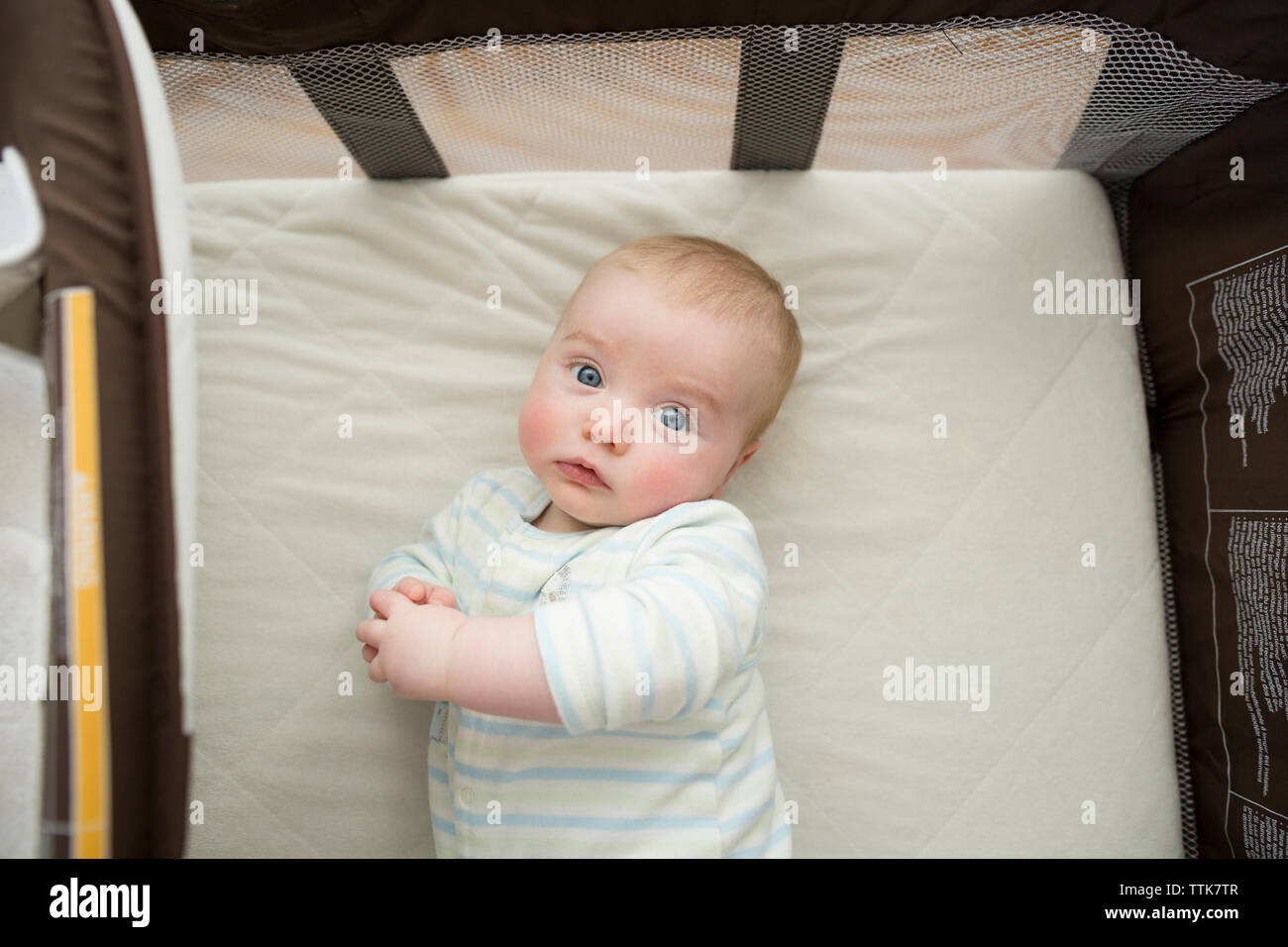 Overhead Portrait von cute baby boy liegen auf Matratze in Pack n' spielen zu Hause Stockfoto