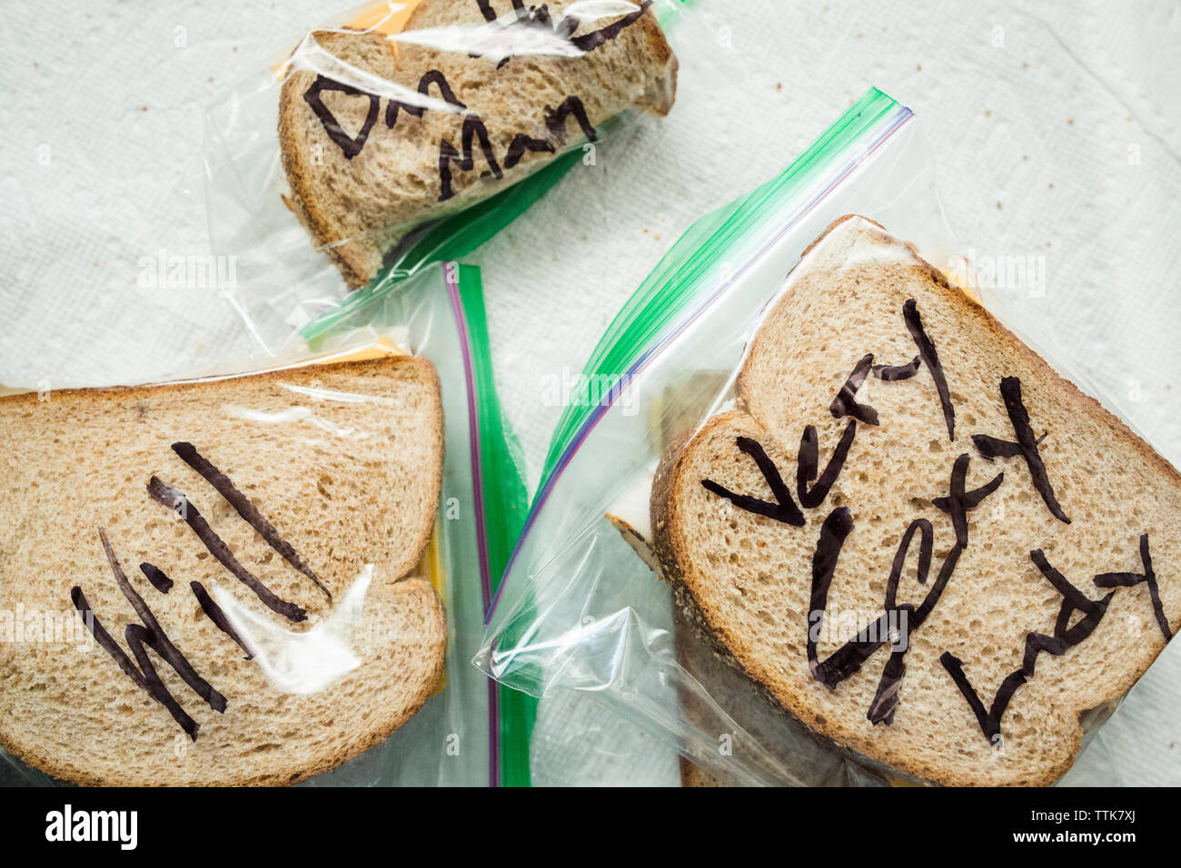 Ansicht von oben von Sandwiches in Plastiktüten mit Text in Tabelle Stockfoto