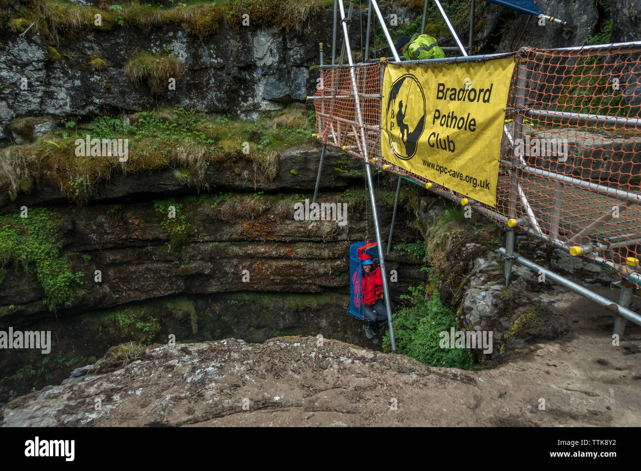 Ein Tourist ist in klaffende Gill von der Bradford Schlagloch Club, eine der größten bekannten unterirdischen Kammern winched in Großbritannien. Die Höhle ist nur offen Stockfoto