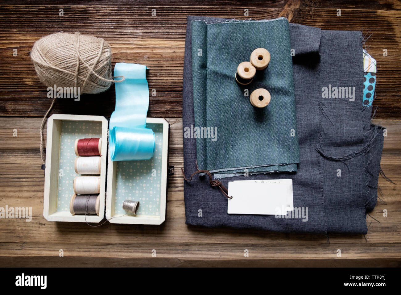 Ansicht von oben aus Stoff mit Näheinrichtungen auf hölzernen Tisch Stockfoto