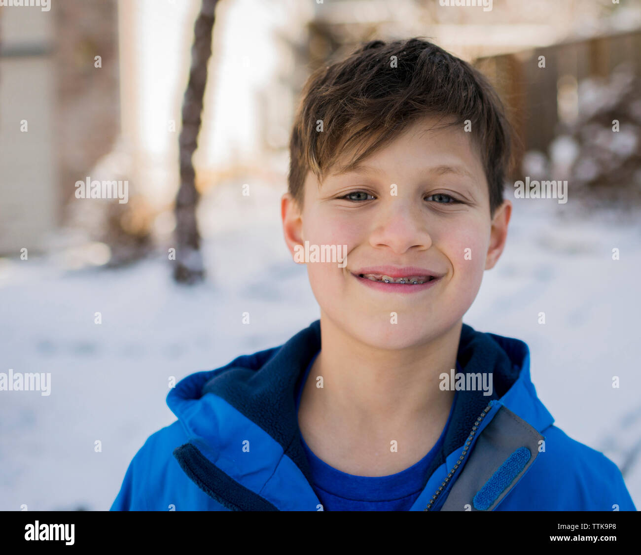 Porträt der lächelnde Junge mit Zahnspange tragen warme Kleidung im Winter Stockfoto