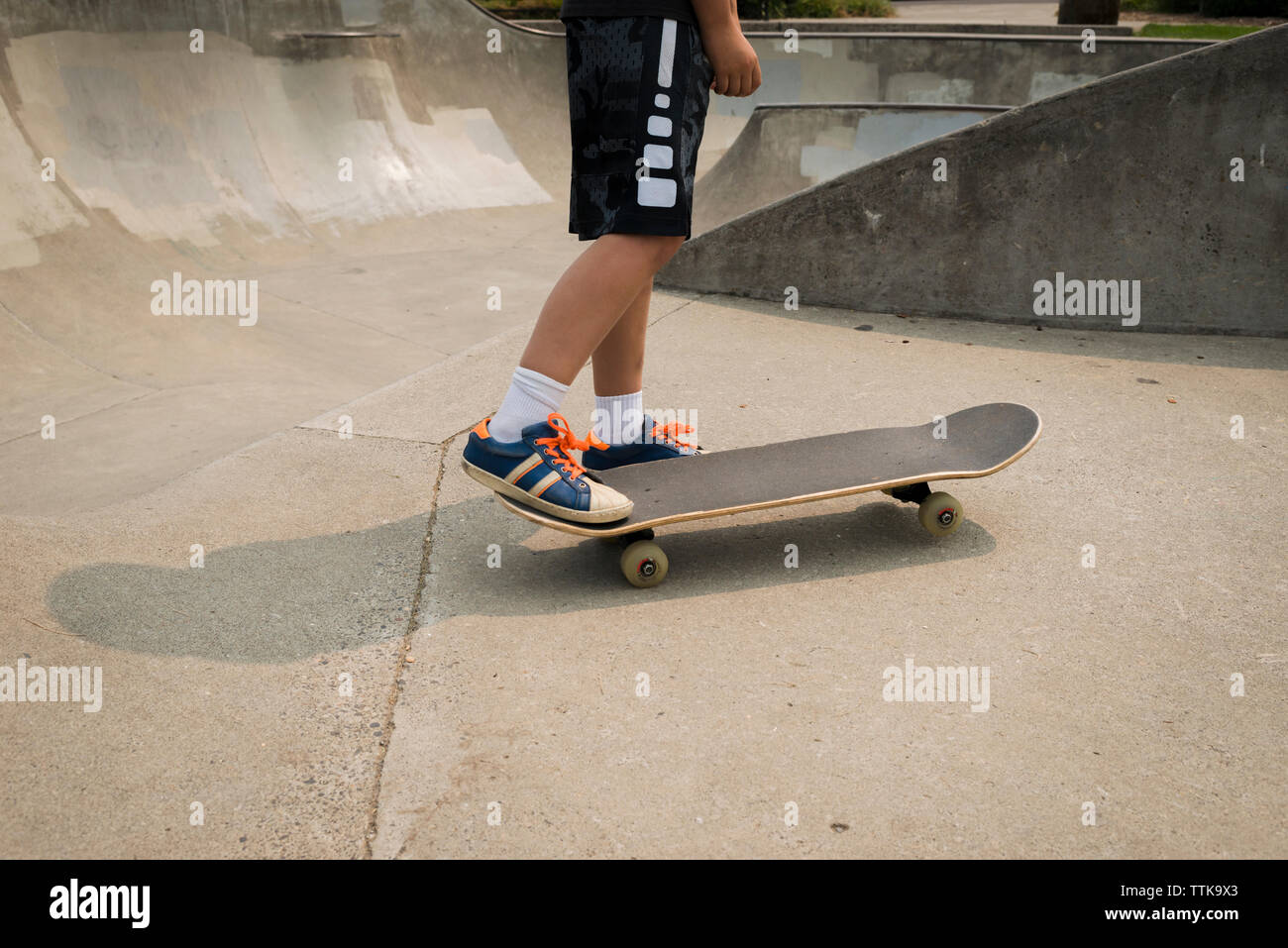 Niedrige Abschnitt der Boy skateboarding auf Sport Rampe im Park Stockfoto