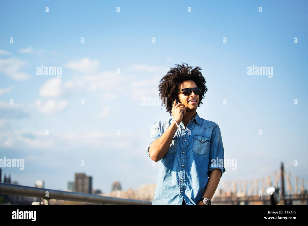 Junger Mann am Telefon sprechen, während sich gegen Stadtbild Stockfoto