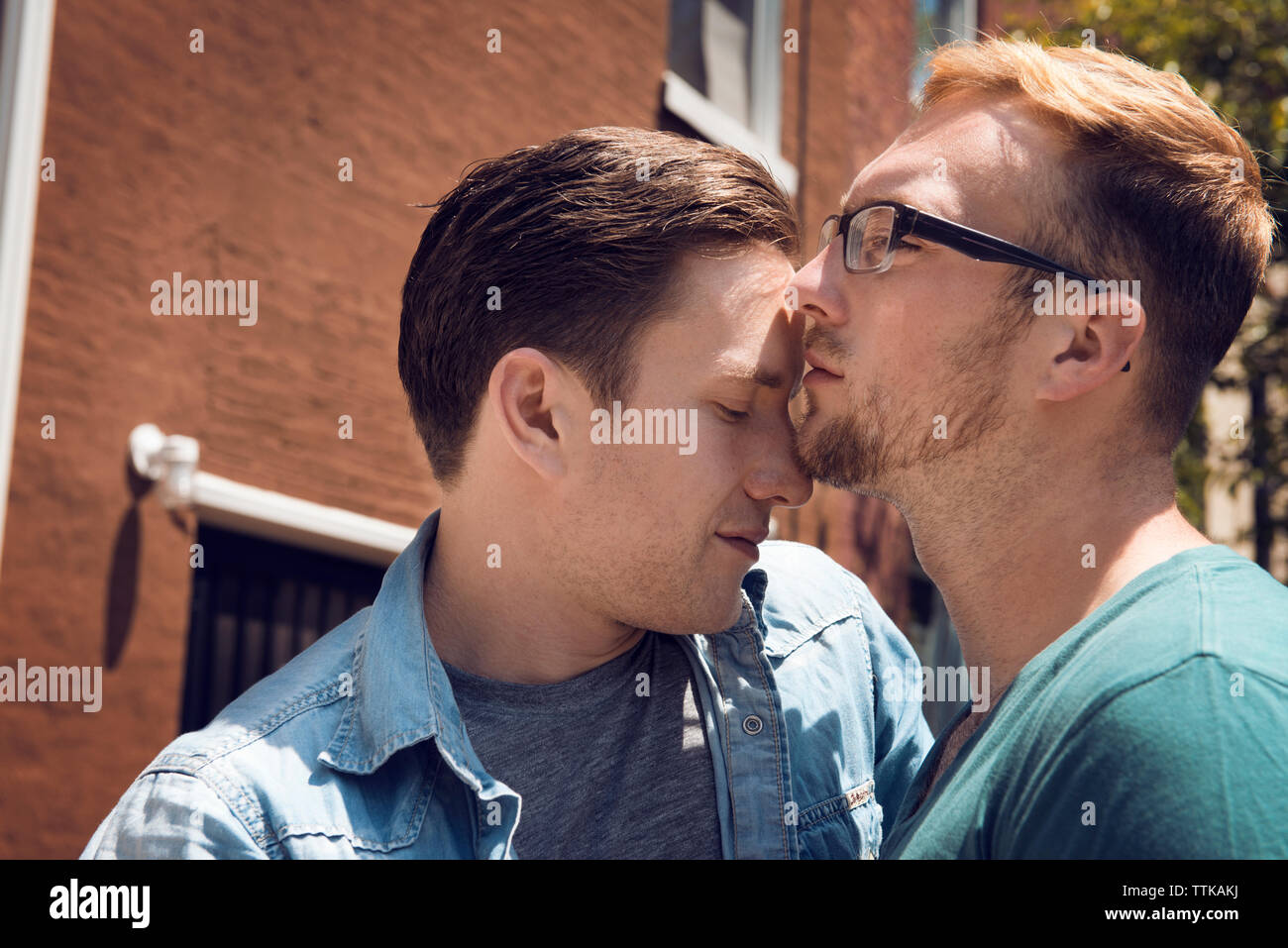 Homosexuelles Paar umarmen beim Stehen vor dem Haus Stockfoto