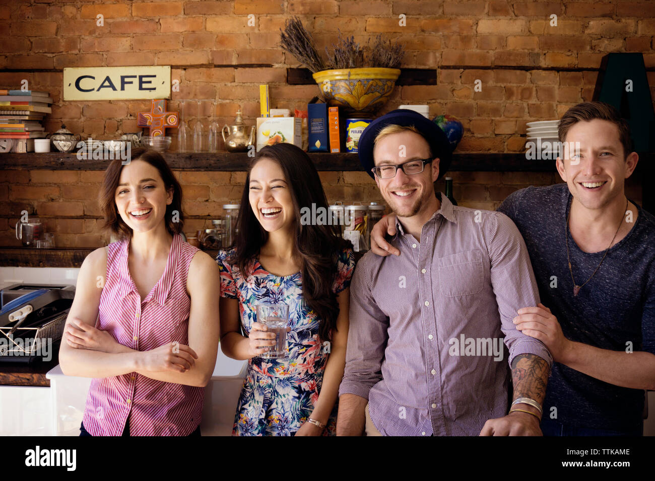 Portrait von glücklichen Freunde stehend gegen den Küchentisch Stockfoto