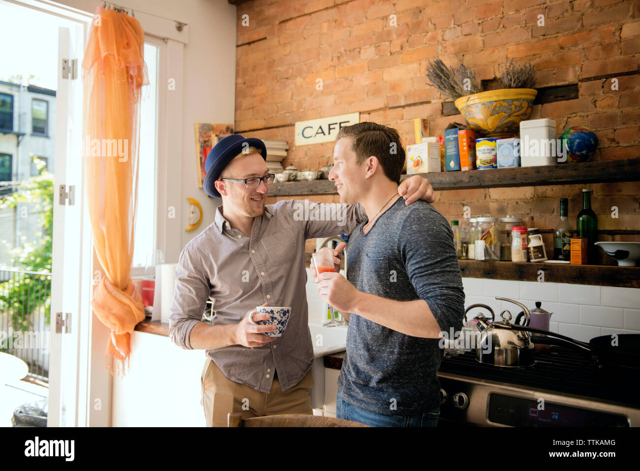 Homosexuelles Paar stehend gegen die Arbeitsplatte in der Küche zu Hause. Stockfoto