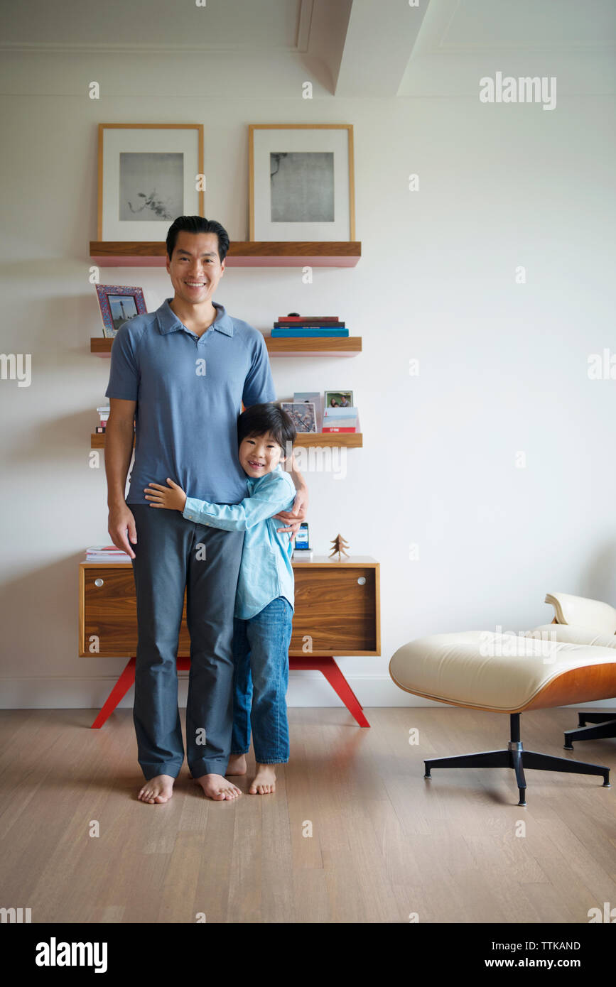 Porträt der glückliche Vater und Sohn sich gegen Wand zu Hause Stockfoto