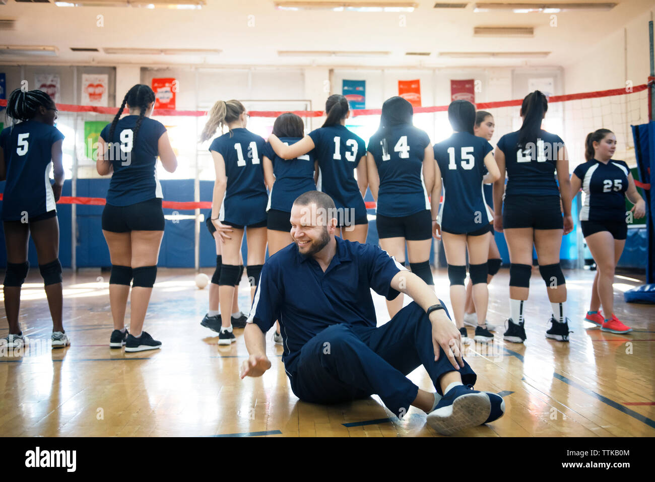 Männliche Trainer mit weiblichen Sport Team in Hof Stockfoto