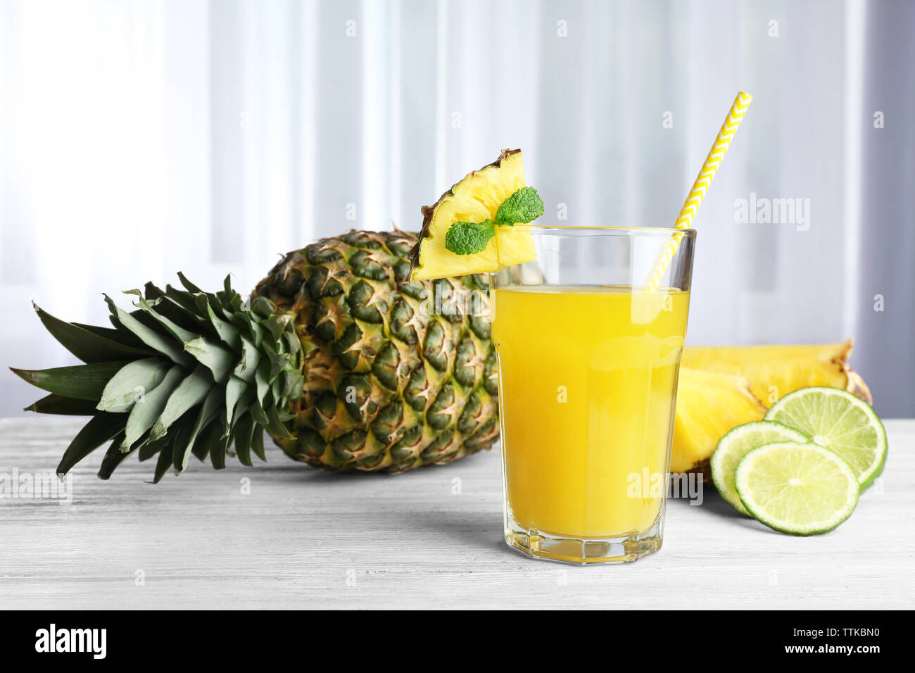 Glas Saft, Ananas und Limette auf den Tisch Stockfoto