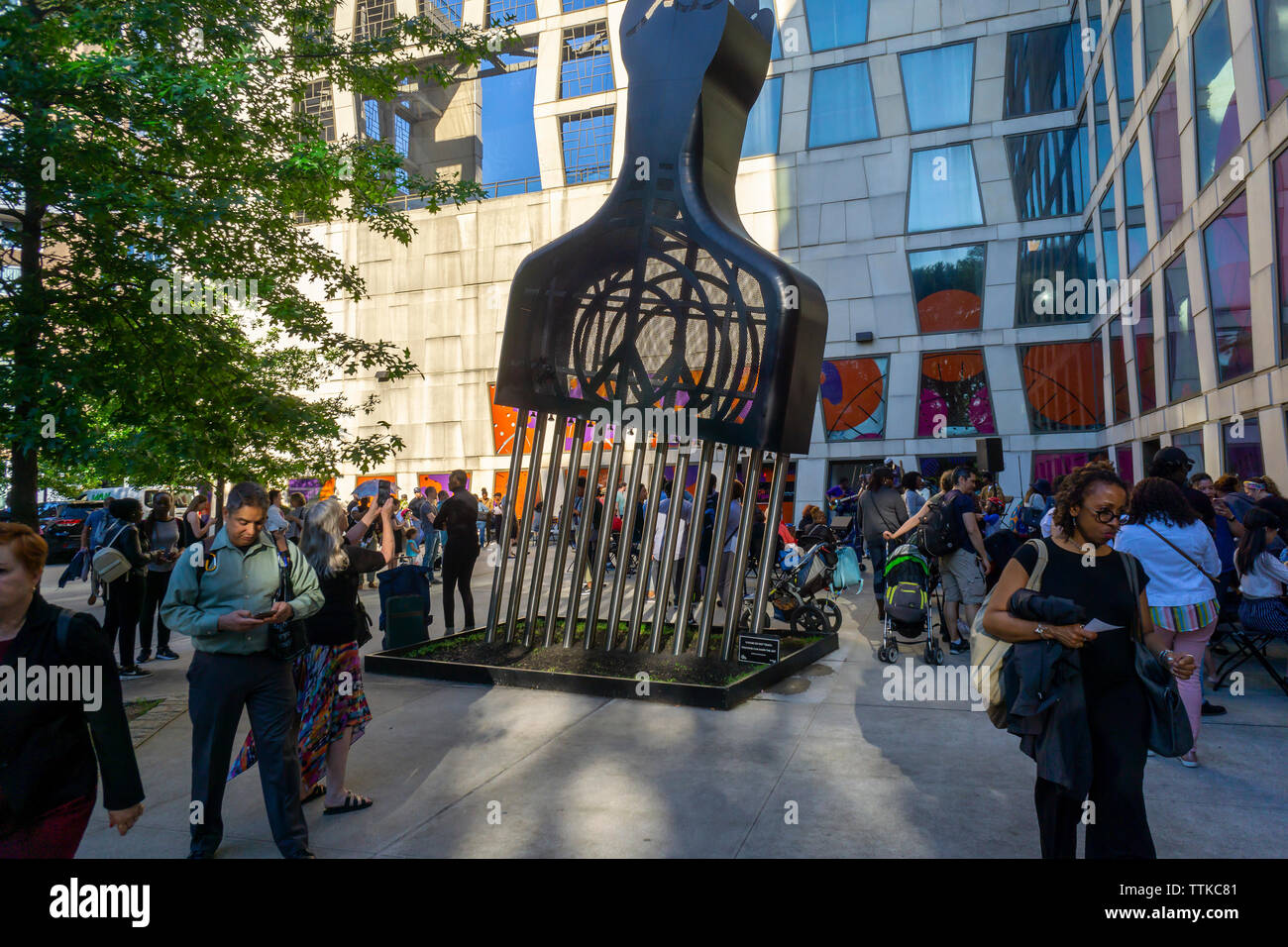 Menschenmassen rund um Hank Willis Thomas' "Alle Macht alle Menschen" in der Plaza der Afrika Center auf der Fifth Avenue am Rande von Harlem während der Museum Mile Festival am Dienstag, 11. Juni 2019. (© Richard B. Levine) Stockfoto