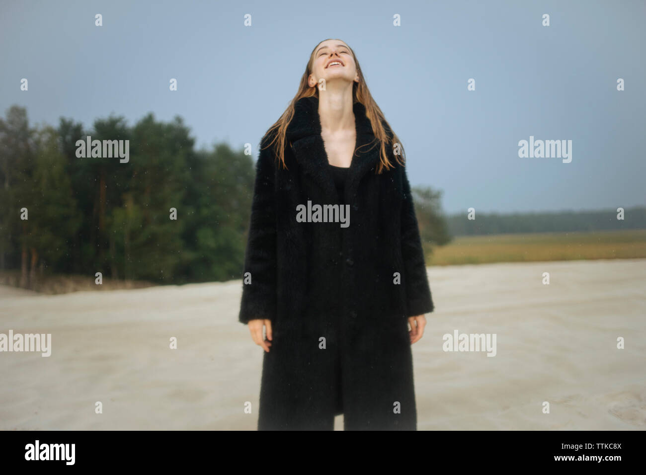 Mädchen stehen auf dem Sand zurück lächelnd mit dem Kopf Stockfoto