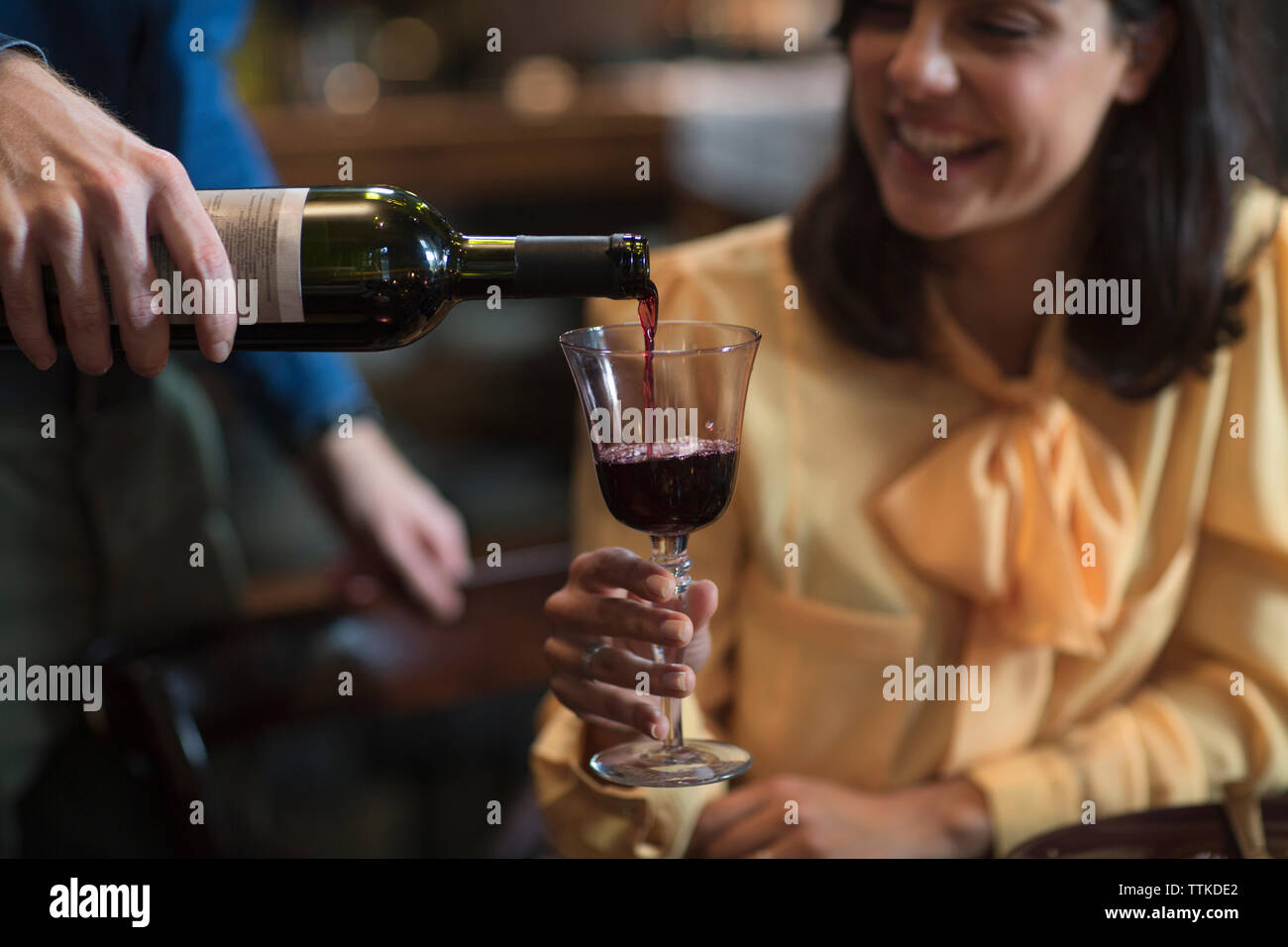 Mann, der Wein an die Frau während der weihnachtsfeier gießt Stockfoto