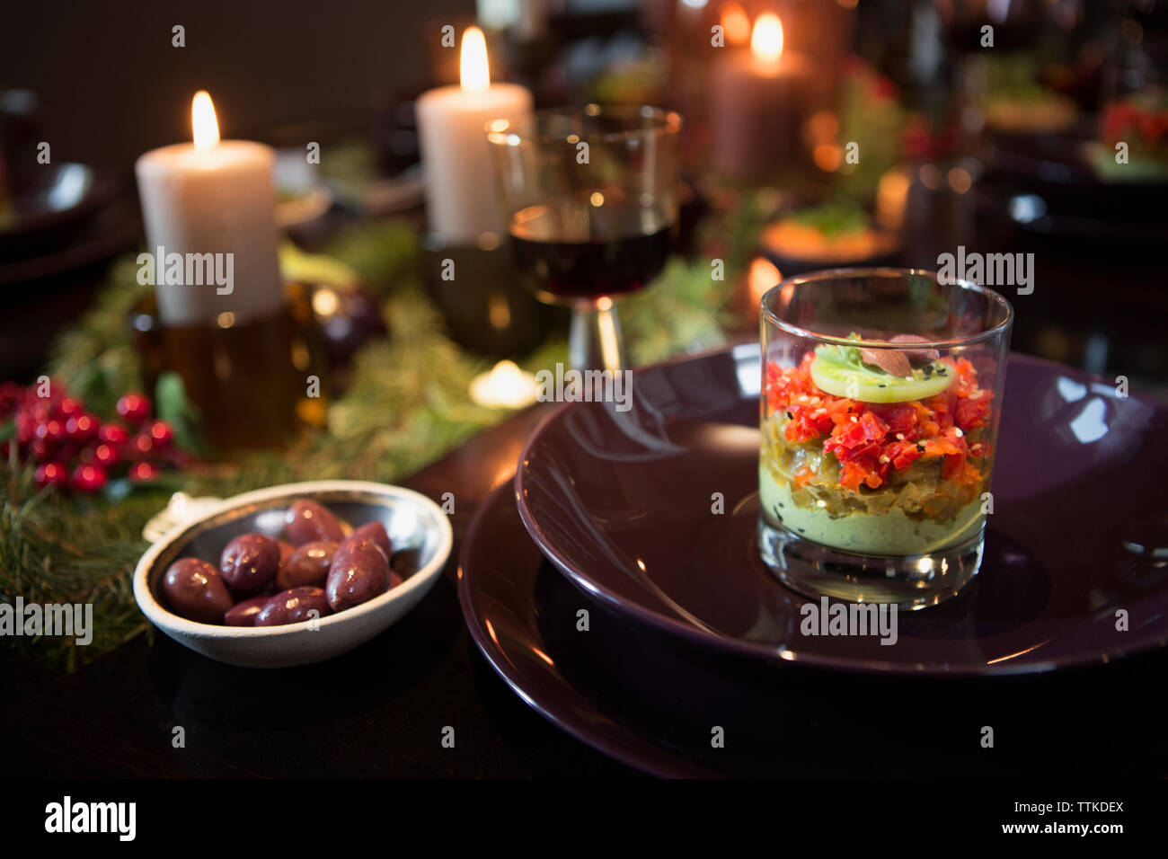 Nahaufnahme des Essens, das während weihnachten gegen brennende Kerzen serviert wird Stockfoto