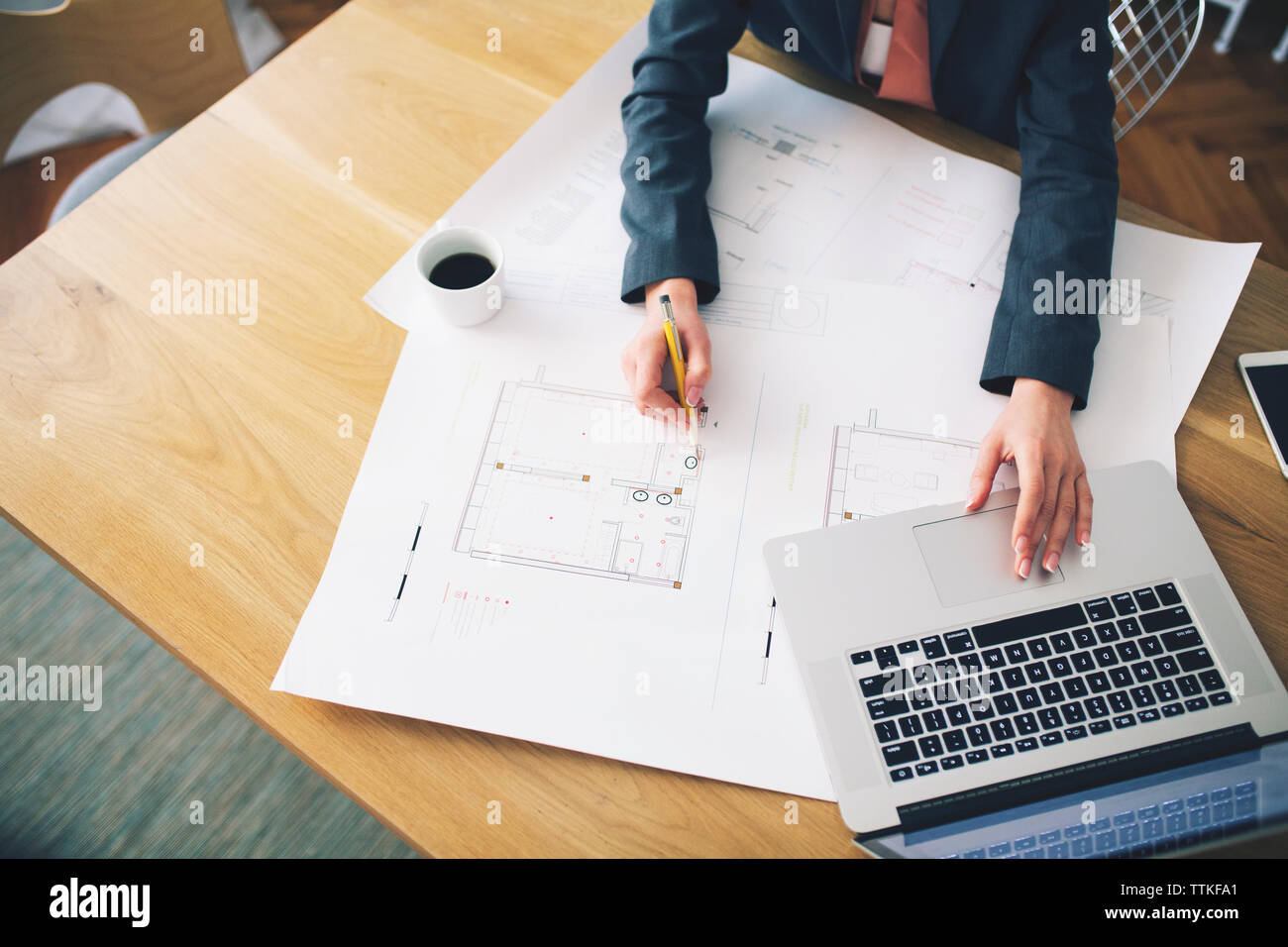 Zugeschnittenes Bild der Unternehmerin Analyse blueprint am Tisch Stockfoto