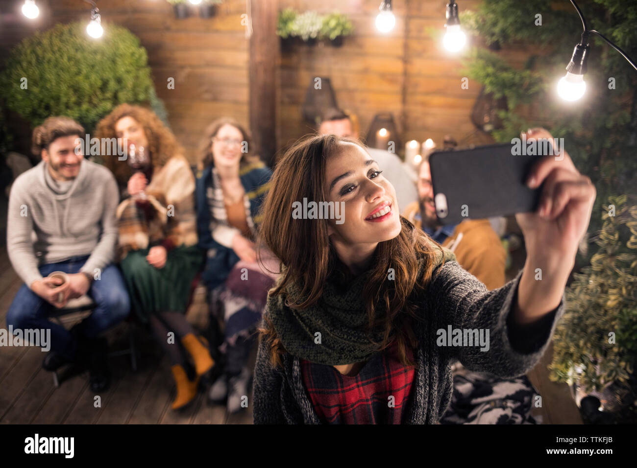 Frau unter selfie mit Freunden im Hinterhof in der Nacht Stockfoto