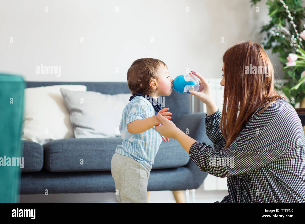 Mutter Unterstützung der Sohn im Trinkwasser zu Hause Stockfoto