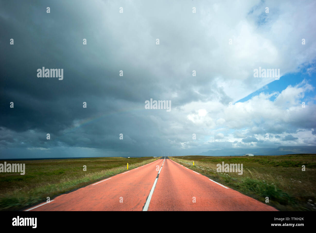 Malerischer Blick auf leere Straße inmitten von Feld gegen bewölkter Himmel Stockfoto