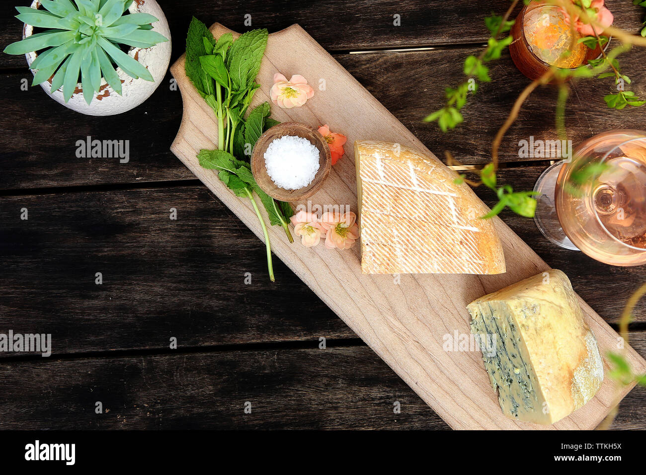 Hohe Betrachtungswinkel von Käse mit Wein und Pflanzen auf hölzernen Tisch Stockfoto