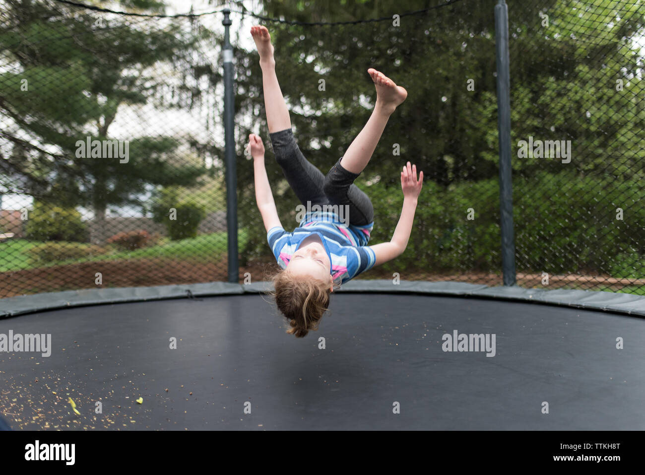 Verspielte Mädchen auf Trampolin im Park springen Stockfoto