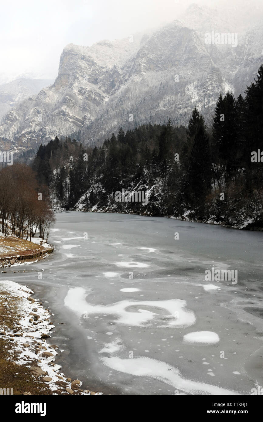 Malerischer Blick auf gefrorenem See gegen Berge im Winter Stockfoto