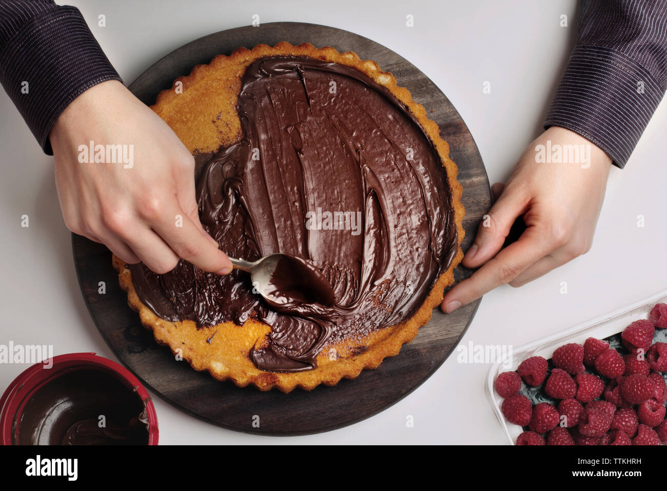 Zugeschnittenes Bild des Menschen verbreiten geschmolzene Schokolade auf Start Stockfoto