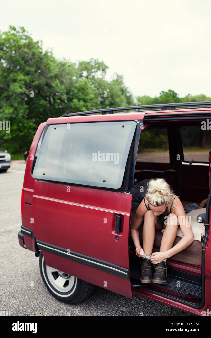 Frau Schnürsenkel binden während der Sitzung in Van auf der Straße Stockfoto
