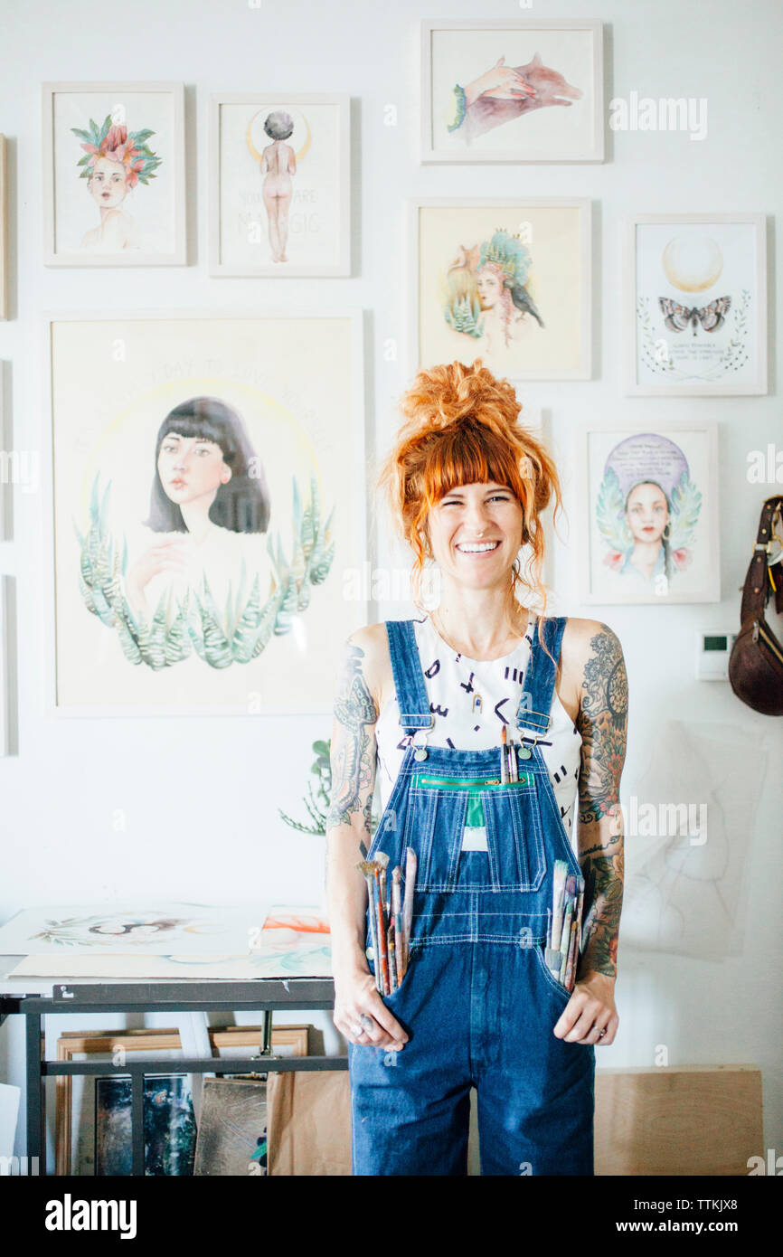 Portrait von lächelnden Artist mit Händen in den Taschen der ständigen im Studio Stockfoto