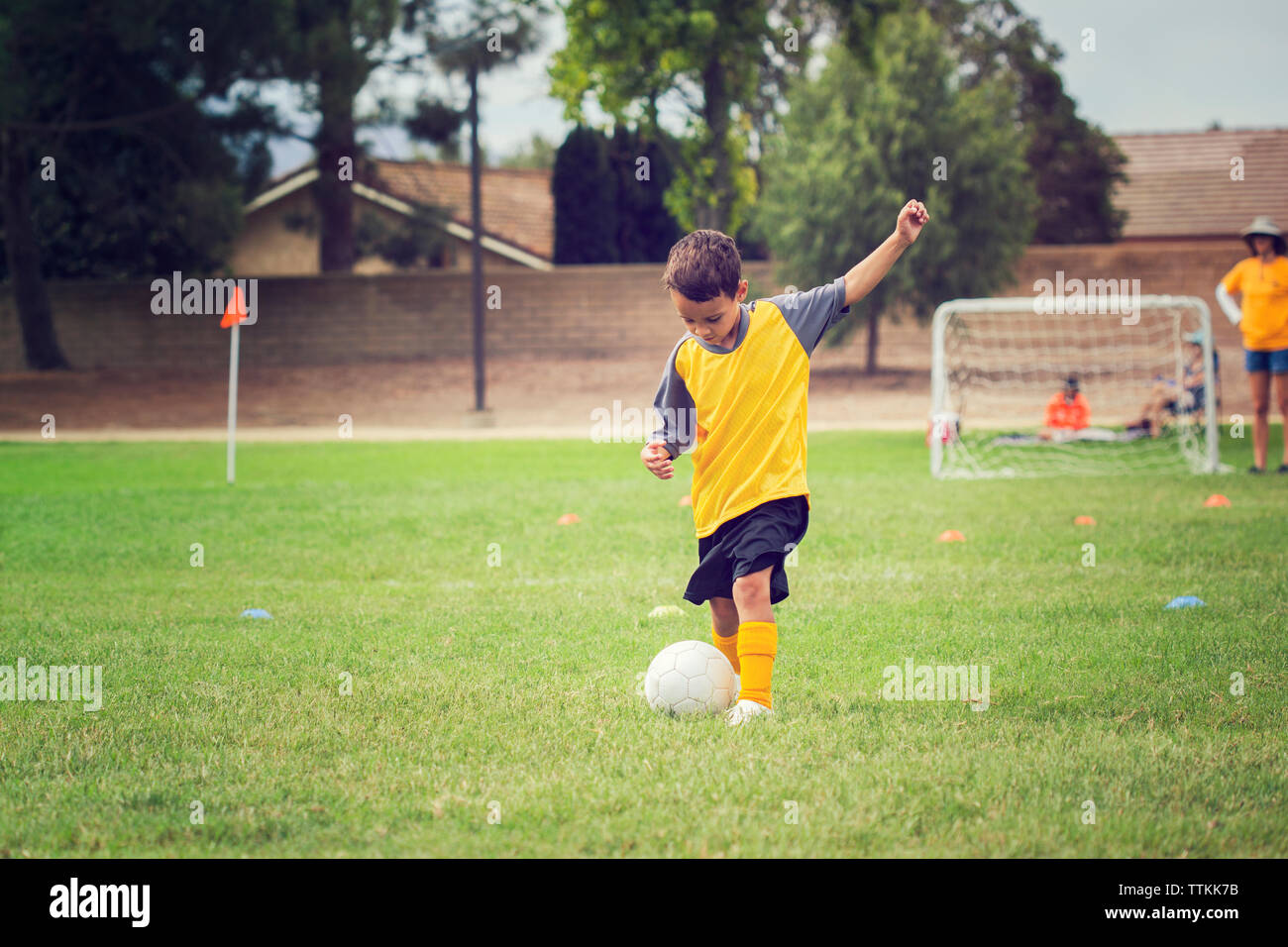 Junge spielt Fußball auf der Wiese Stockfoto