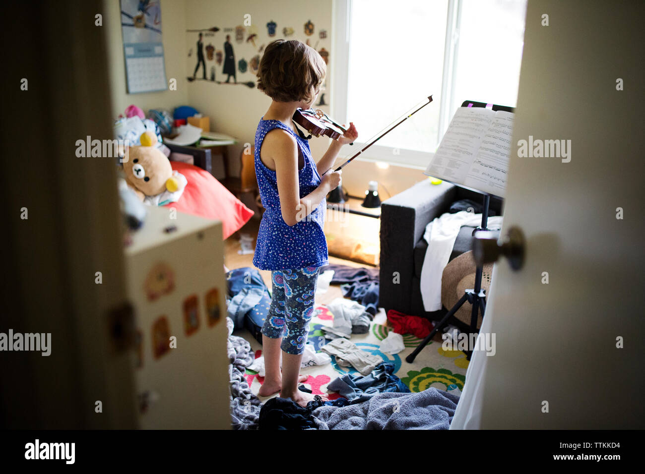 Ansicht der Rückseite des Mädchen spielen Geige im Schlafzimmer Stockfoto