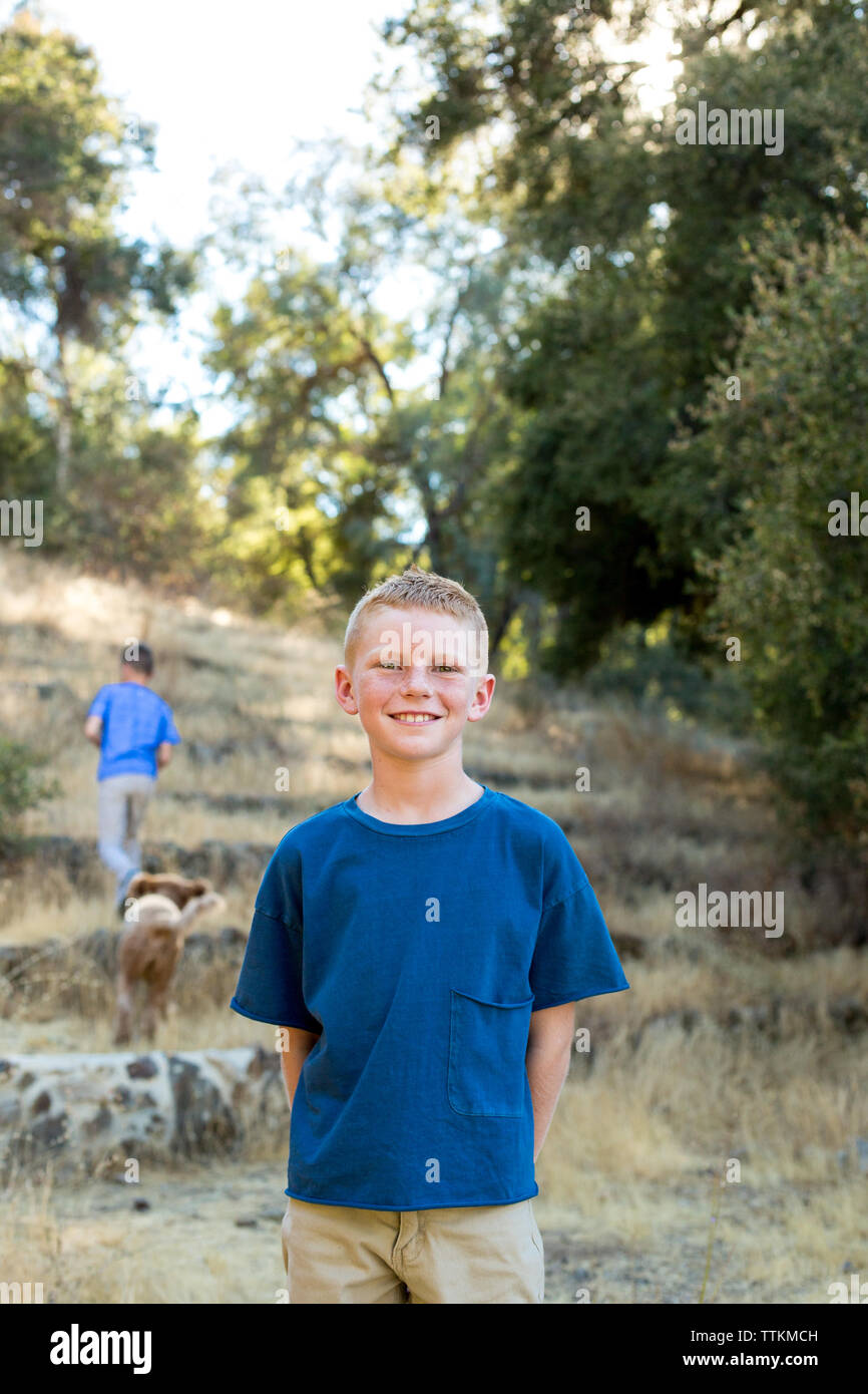 Porträt eines Jungen lächelnd, während sie in der Natur Stockfoto