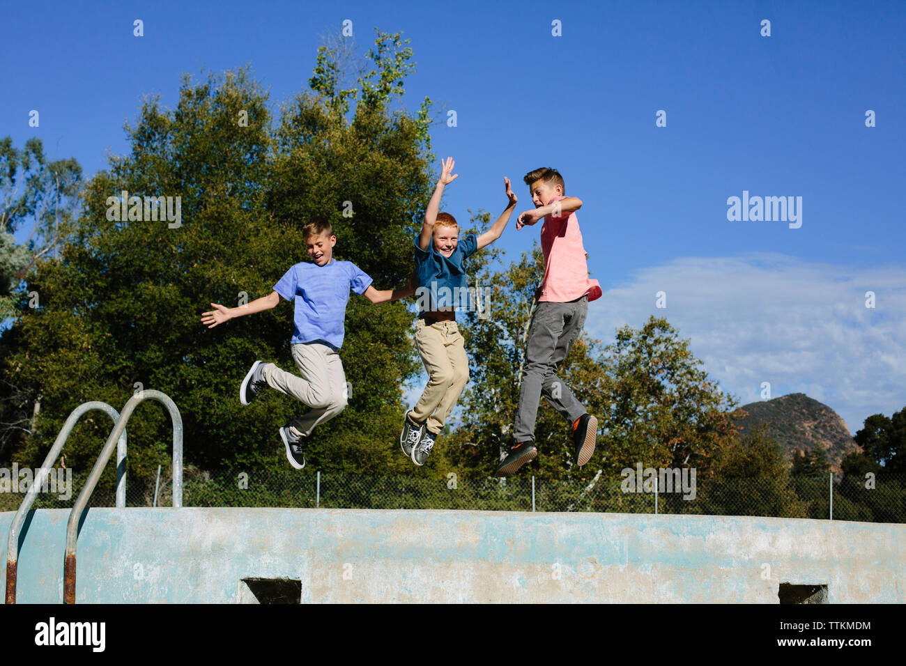 Drei Brüder fröhliches Suchen, während in der Luft nach dem Springen Stockfoto