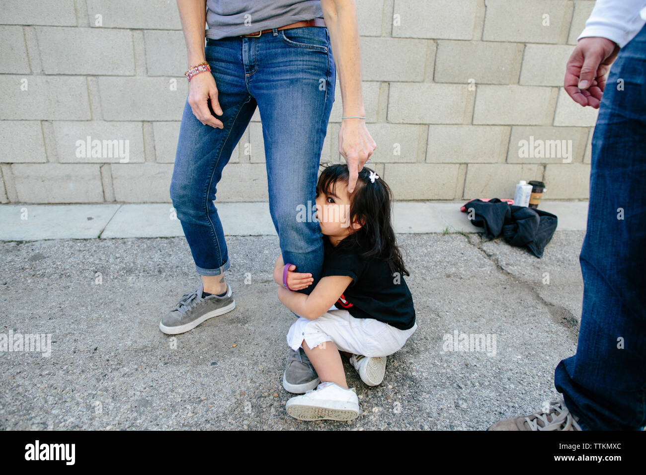 Ein Schüchternes Kind Mädchen packt fest auf Mutters Bein Stockfoto