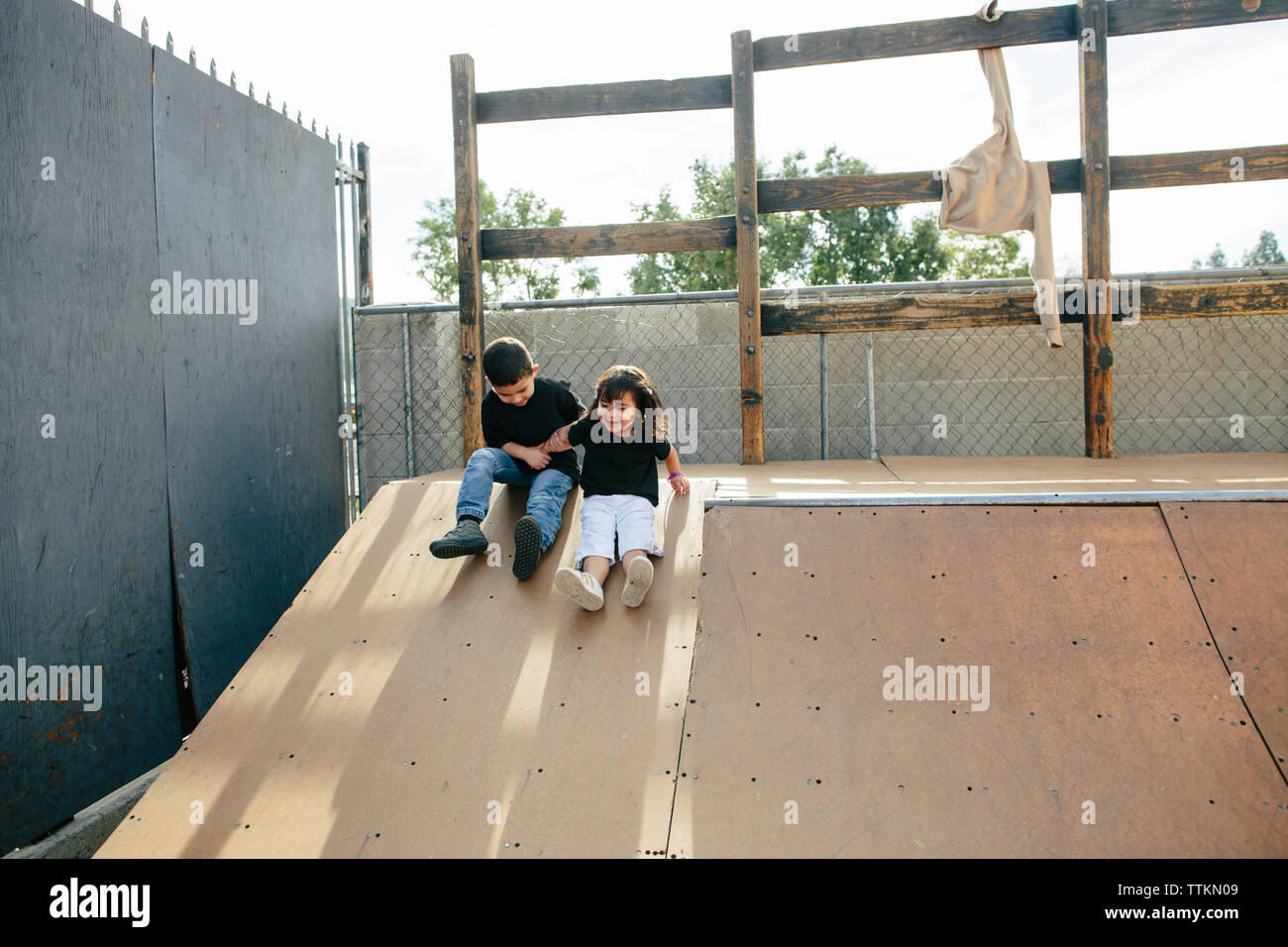 Bruder und Schwester nach unten schieben einen Skate Rampe auf Ihre Böden Stockfoto